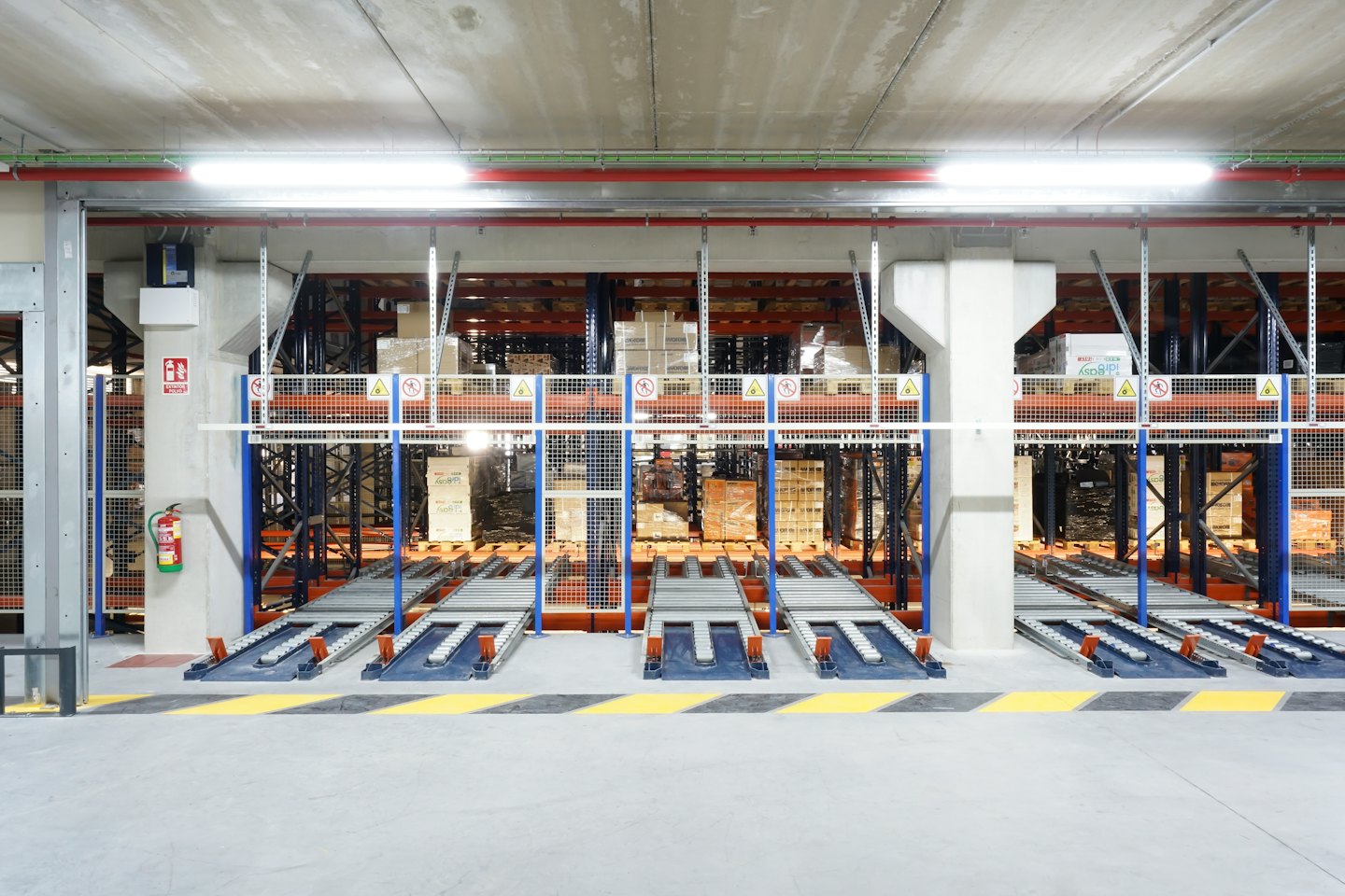Magazzino automatizzato con scaffalature per pallet e sistemi di trasporto.